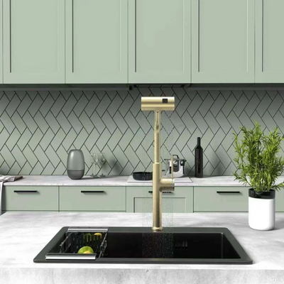 Modern kitchen with a gold faucet and green cabinets