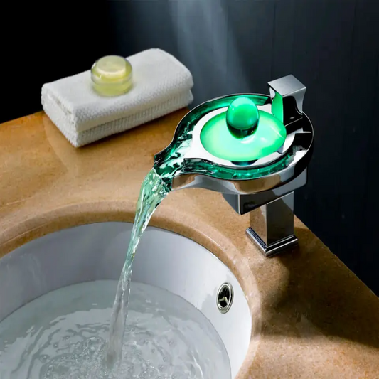 Bathroom sink with a modern faucet pouring water, featuring a green light.